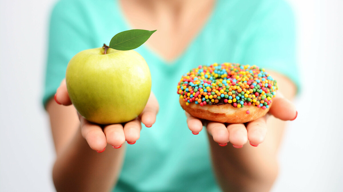 zur Wahl stehen ein Apfel und ein Donut mit bunten Streuseln