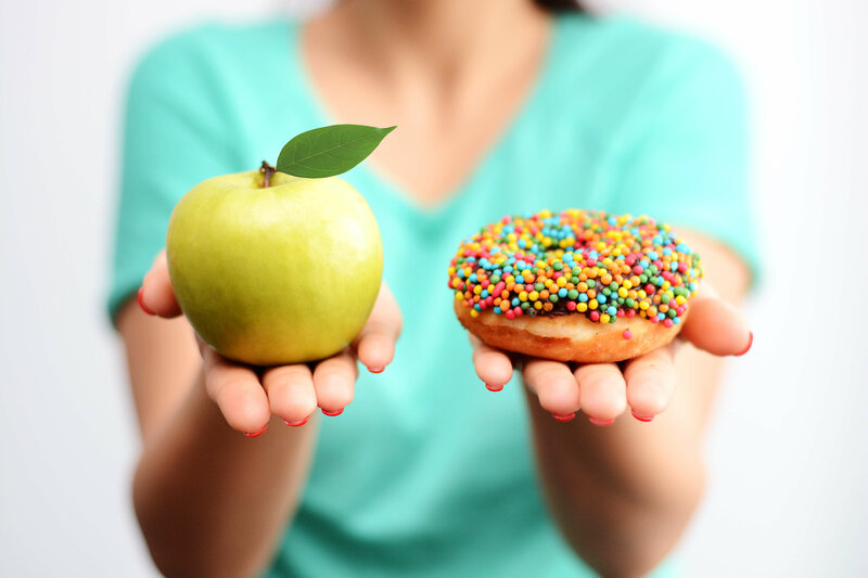 zur Wahl stehen ein Apfel und ein Donut mit bunten Streuseln