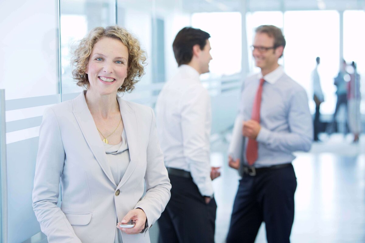 lächelnde junge Frau im hellen Business-Outfit