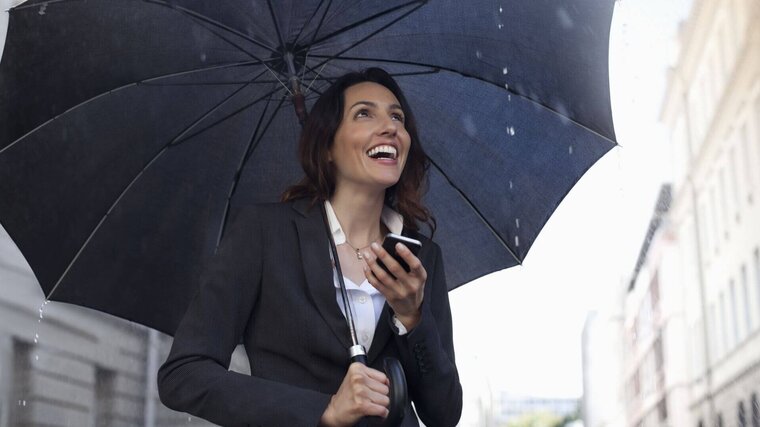 Lachende Frau unter Regenschirm, Resilienz, Schutzschirm