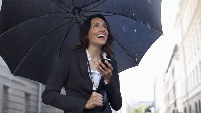 Lachende Frau unter Regenschirm, Resilienz, Schutzschirm