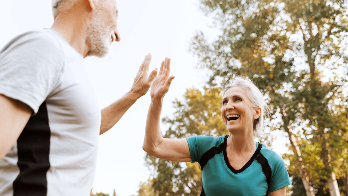 Zwei Personen klatschen beim Sport die Hände zusammen