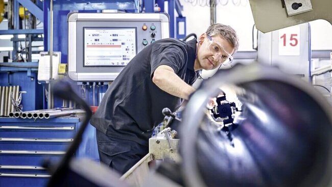 Mann der an einer Maschine arbeitet