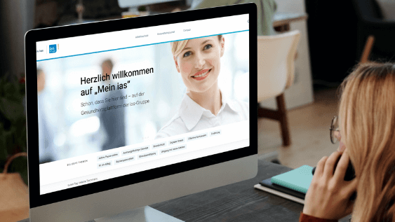 Plattform "Mein ias" Frau schaut auf den Bildschirm eines Computers mit der Startseite von "Mein ias"-Portal