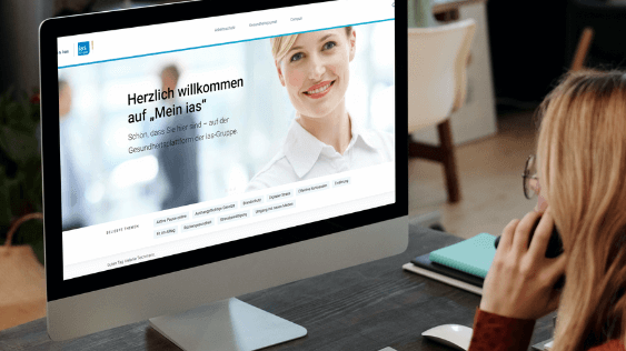 Plattform "Mein ias" Frau schaut auf den Bildschirm eines Computers mit der Startseite von "Mein ias"-Portal