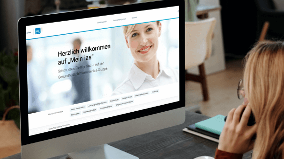 Frau schaut auf den Bildschirm eines Computers mit der Startseite von "Mein ias"-Portal