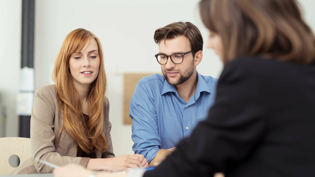 Beratungsgespräch mit drei Personen am Tisch