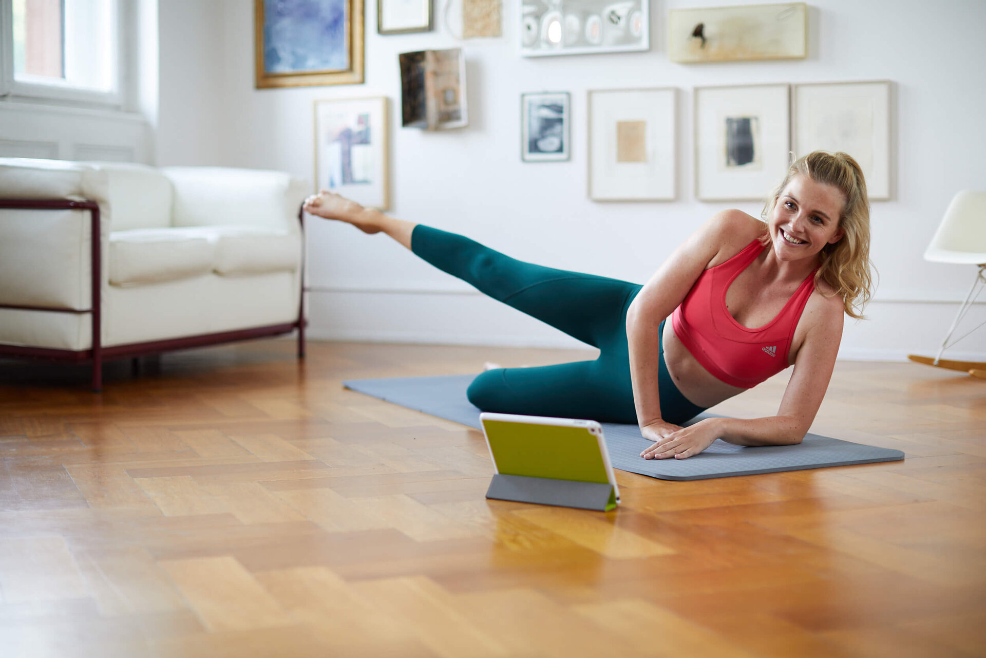 junge Frau beim Online-Home-Workout vor Laptop