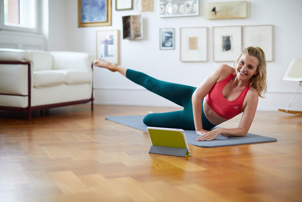 Mitarbeiter-Benefit Online-Fitness-Studio junge Frau beim Online-Home-Workout vor Laptop