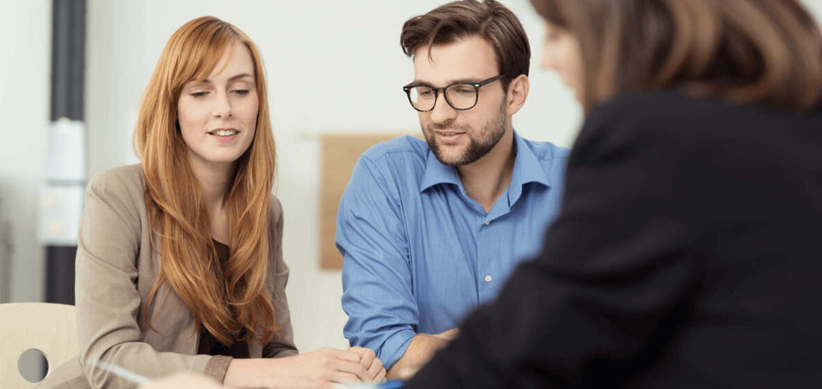 Beratungsgespräch mit drei Personen am Tisch