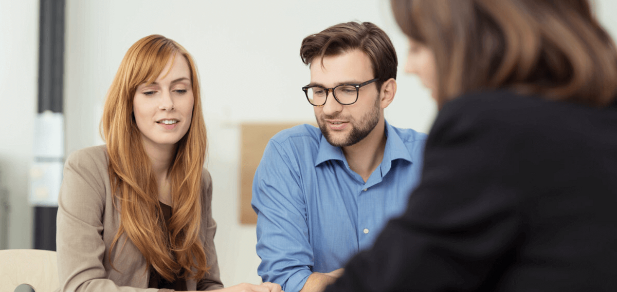 Beratungsgespräch mit drei Personen am Tisch