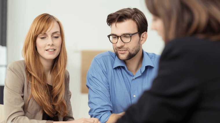 Beratungsgespräch mit drei Personen am Tisch