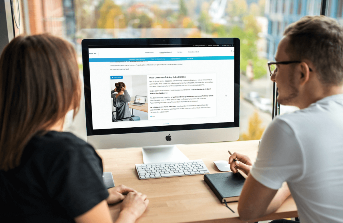 Zwei Personen schauen gemeinsam auf einen Bildschirm 