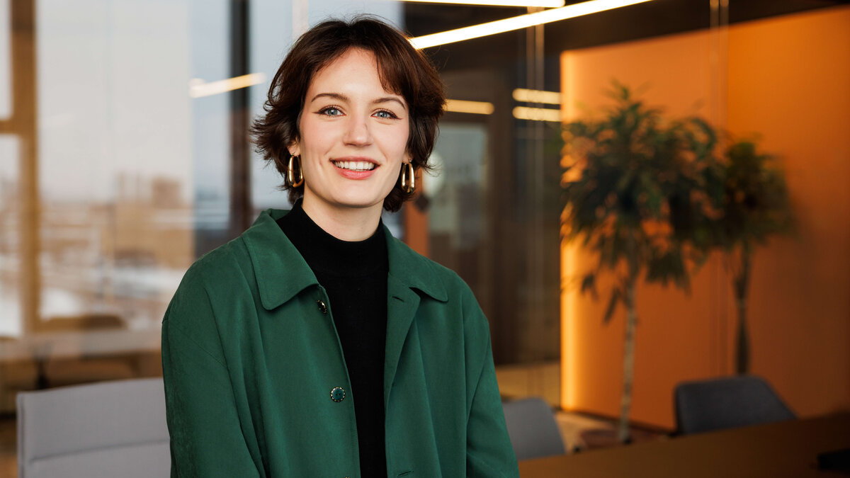 junge Frau, grünes hemd, in moderner gebäudeumgebung