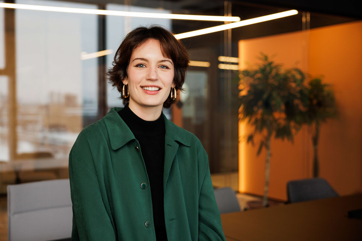 junge Frau, grünes hemd, in moderner gebäudeumgebung