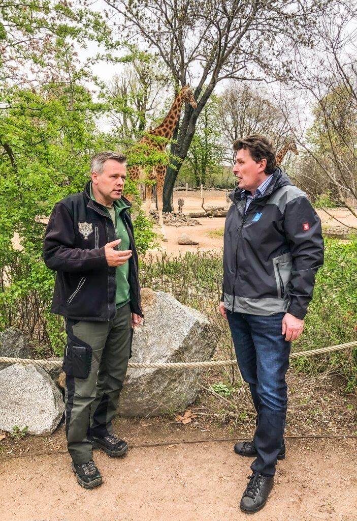 Zwei Personen unterhalten sich vor dem Giraffengehege im Zoo Dresden.