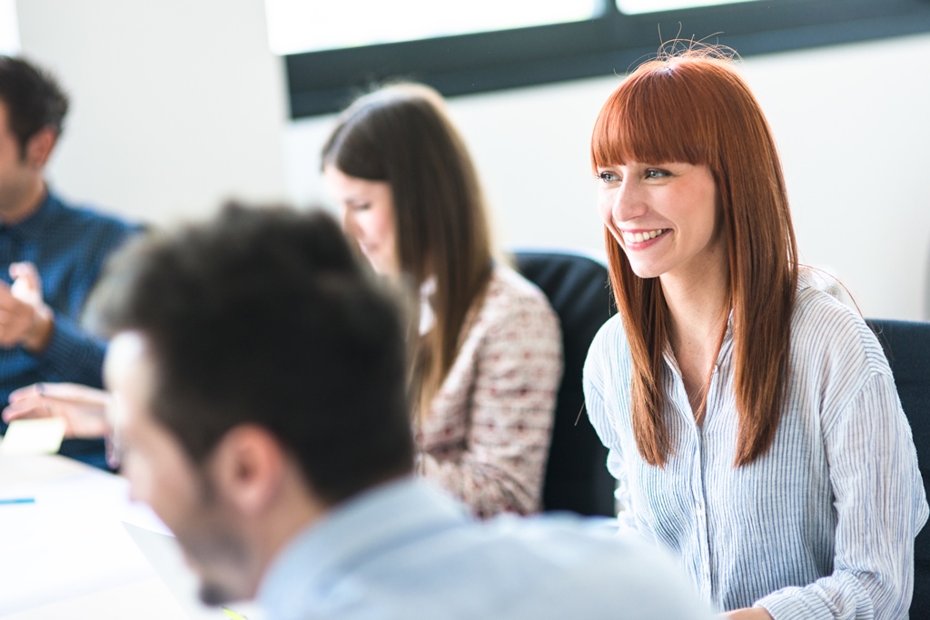 junge Frau mit roten Haare in Team-Besprechung